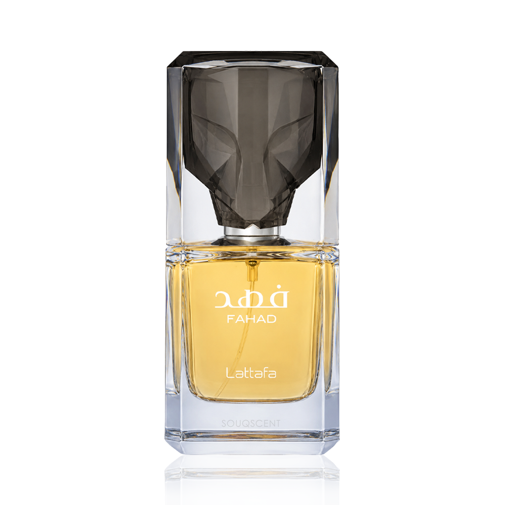 A faceted clear glass perfume bottle with a dark smoky cap and golden-yellow liquid inside, labeled 'FAHAD' and 'Lattafa', on a white background.